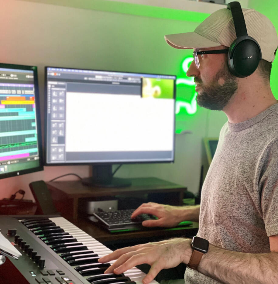 Jon with arms crossed standing on a balcony